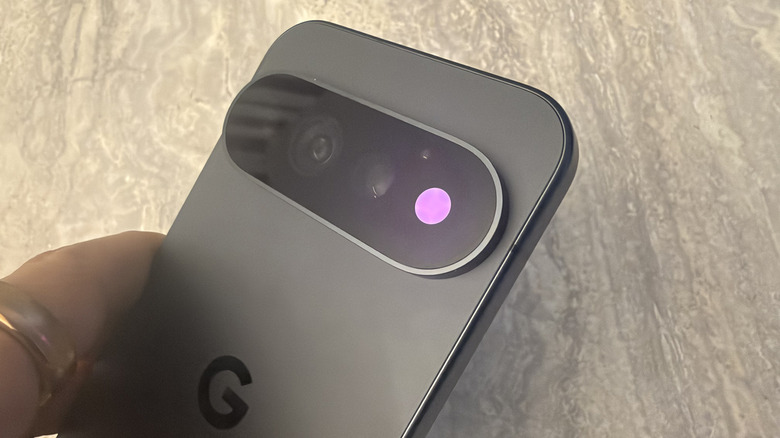 A Google Pixel 11 Pro in hand with the HiLight button shining pink.