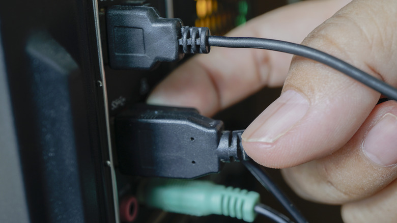 A person plugging an HDMI cable into an HDMI port