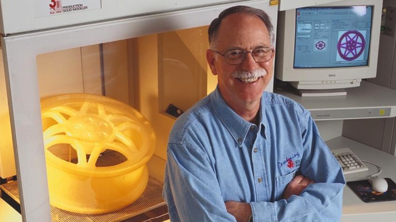 Chuck Hall in front of a 3D resin printer
