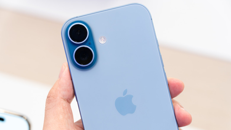 Hand holding a new iPhone 17 Mist Blue in a Store.