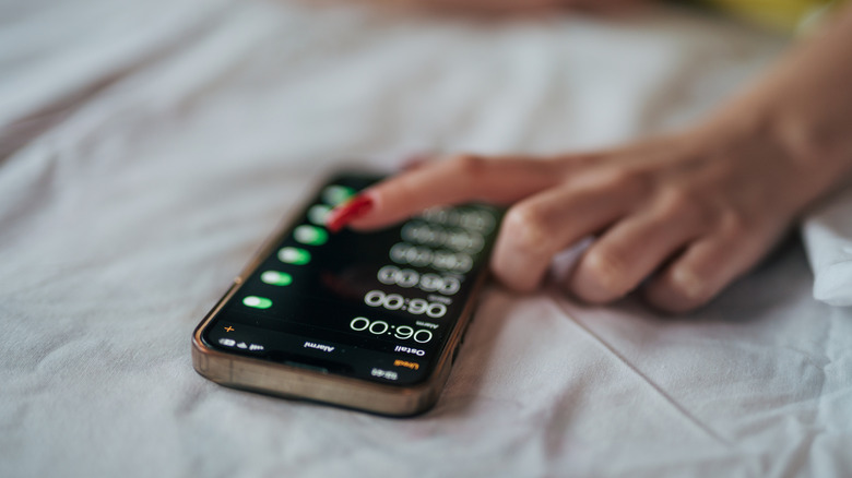 A person selecting multiple alarms on the iPhone.