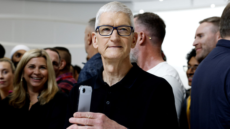 Apple CEO Tim Cook holds a new iPhone during an Apple event
