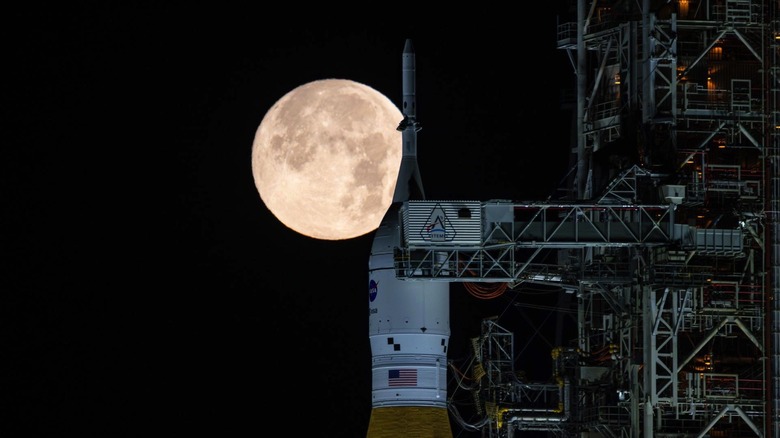 NASA's SLS (Space Launch System) and Orion spacecraft with the full moon in the background.