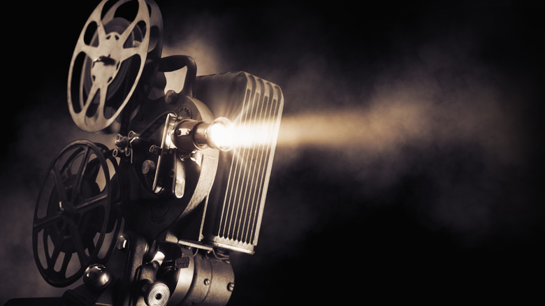 A close-up shot of light emitting from a vintage film projector with a dark background.