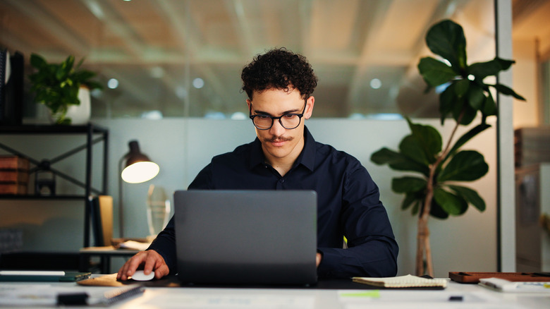 Person looking at a laptop in an office