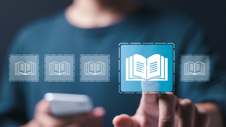 Man touching a digital rendering of a book in mid-air.