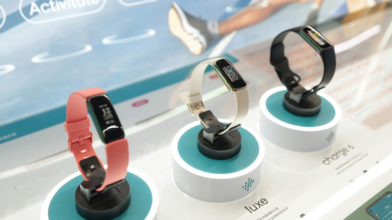 Fitbit fitness bands on a display case.