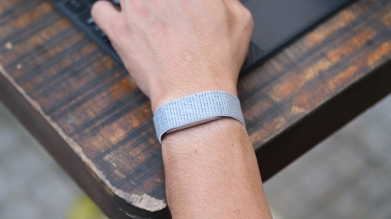 A person's hand with an Amazon Halo fitness band on the wrist.