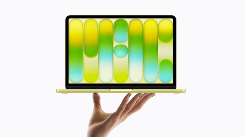 A hand holding the MacBook Neo