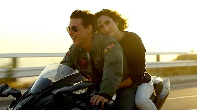 Screenshot from Top Gun: Maverick showing Maverick and Penny Benjamin riding on a motorcycle together.