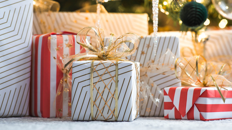 Several gifts wrapped under a tree