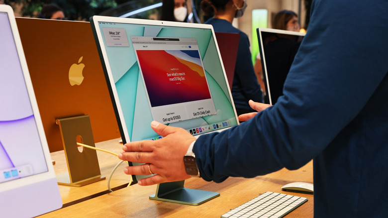 An Apple employee adjusts an iMac color computer
