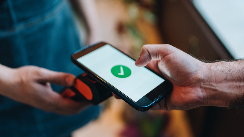 A person confirming payment with NFC on a phone
