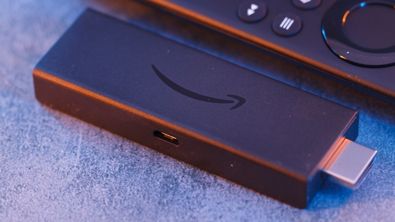 An Amazon Fire TV Stick placed next to its remote.