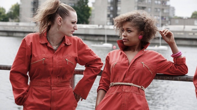 Kelly and Alisha leaning against a metal handrail in "Misfits"