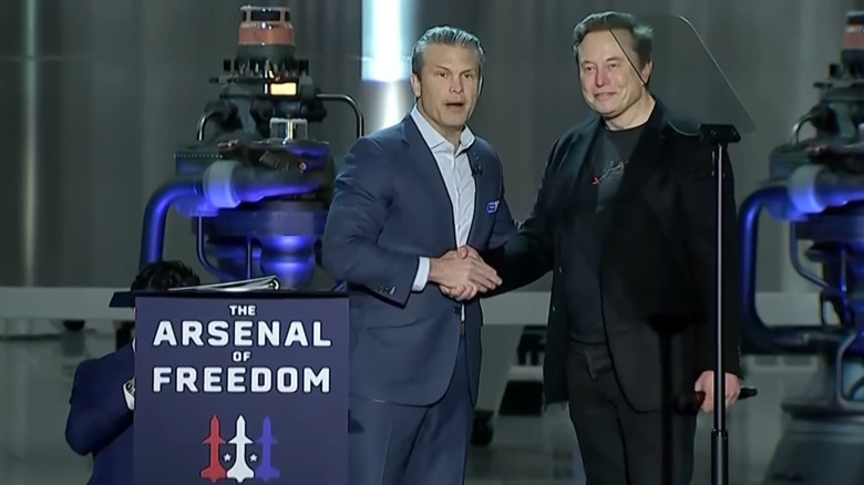 Pete Hegseth (left) and Elon Musk (right) shake hands on stage during the Arsenal of Freedom tour.