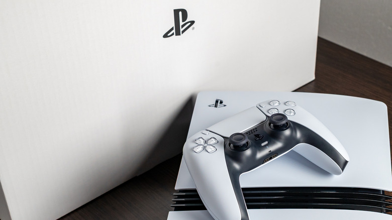 Sony PlayStation 5 controller and console sitting next to box with PlayStation logo visible