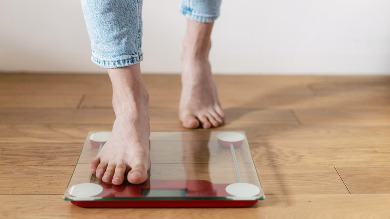 Person stepping on scale.
