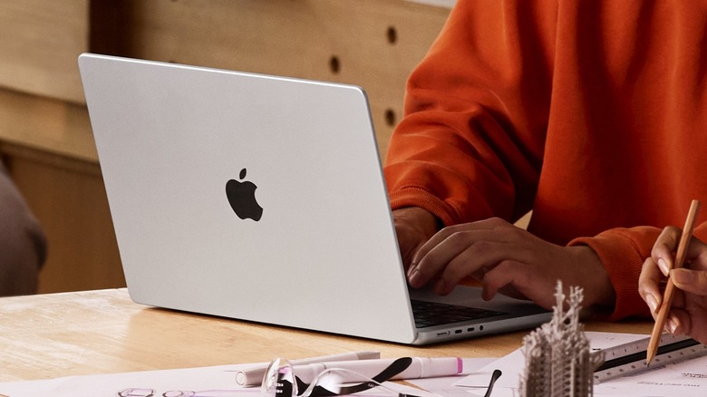 A person using the MacBook Pro M5 surrounded by stationary