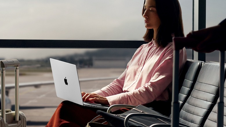A person using the MacBook Pro M5 on an airport
