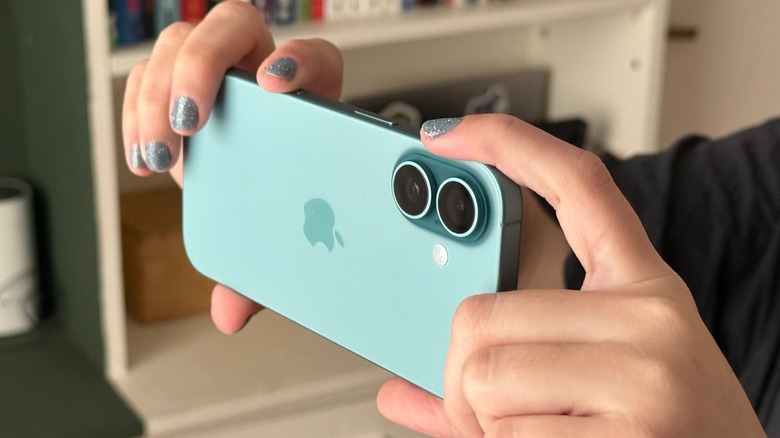 a woman holds an iPhone 16 to take pictures using the Camera Control