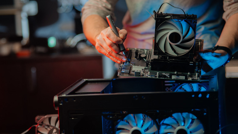 A person repairing a computer with a screwdriver