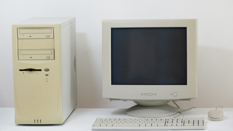 An old computer tower with a CRT monitor and wired keyboard and mouse