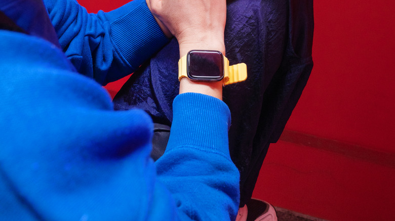 Smartwatch on a wrist and a smartphone in the other hand