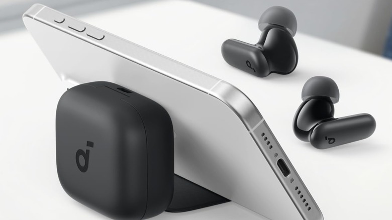 Soundcore P30i Bluetooth black earbuds on table in front of iPhone