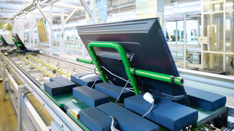 Televisions moving along conveyor belt in assembly area of a TV manufacturing plant