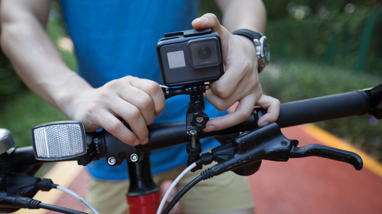 A bicyclist adjusting a GoPro action camera