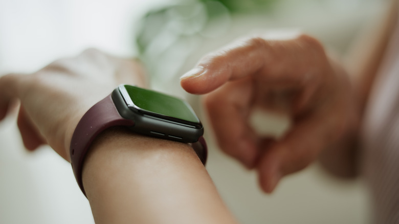 Person interacting with smartwatch on wrist