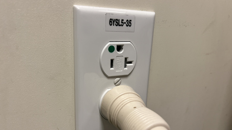 An electrical outlet in a hospital setting with the ground at the top.