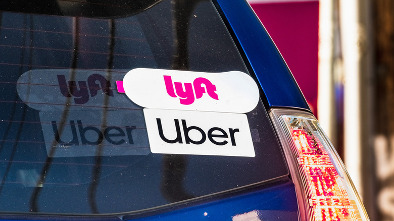 A rideshare car with stickers for both Lyft and Uber