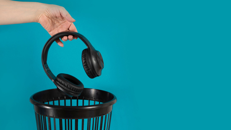 Hand throwing headphones into a bin