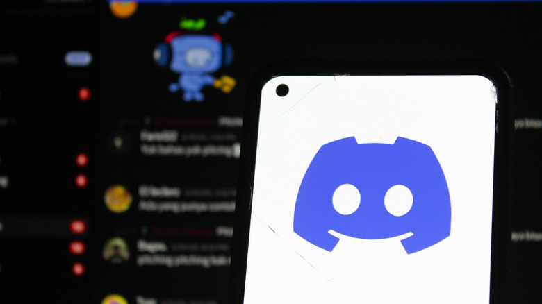 the Discord logo on a phone with the chat screen in the background