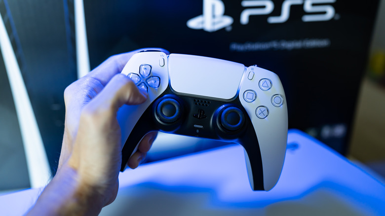 a person holding a PS5 controller