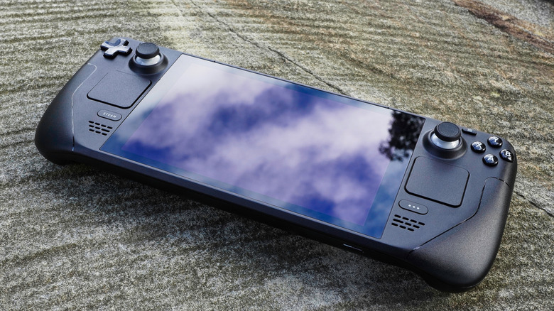 The Steam Deck sitting on a rock outdoors