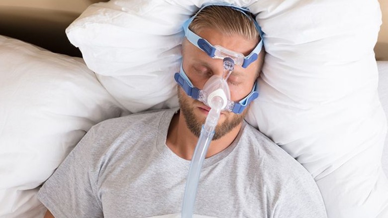 Man wearing CPAP machine to treat sleep apnea