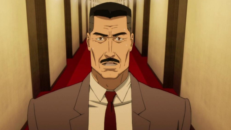 Detective Konakawa in "Paprika" standing in a long hallway with a red carpet