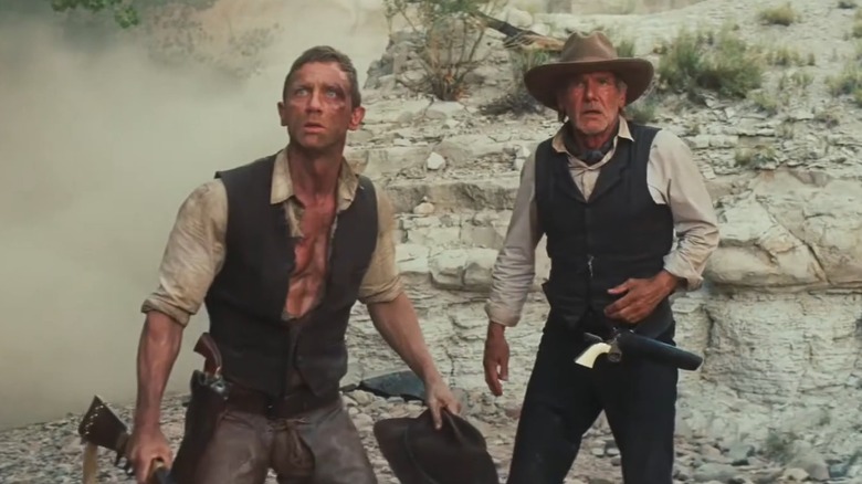 Daniel Craig with a rifle stood next to Harrison Ford in Cowboys & Aliens