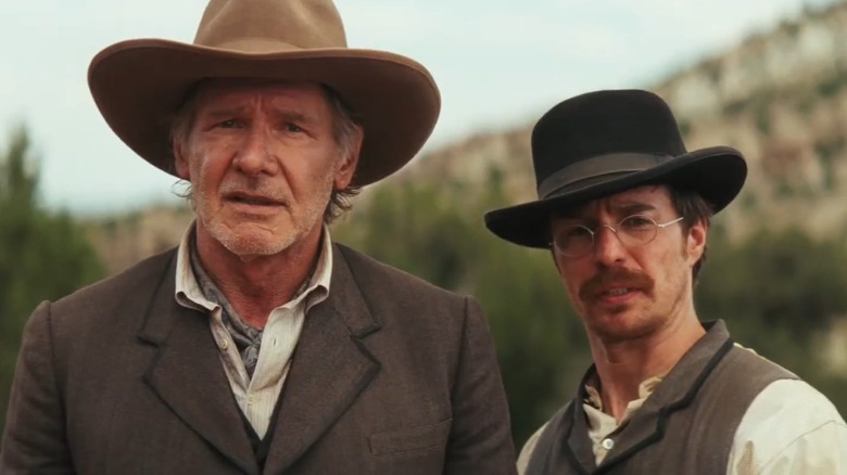 Harrison Ford and Sam Rockwell stood next to each other watching something in Cowboys & Aliens