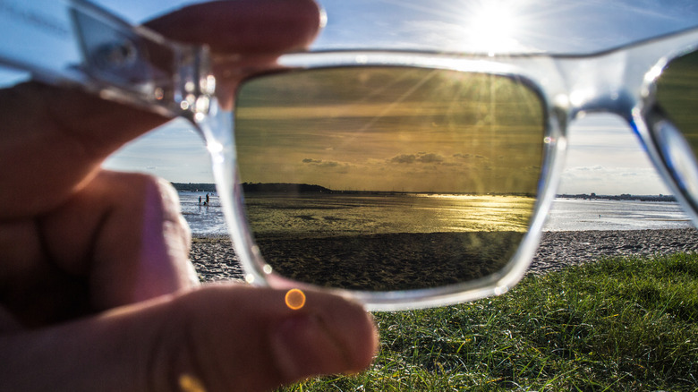 A person looking at a lake through a pair of polarized sunglasses