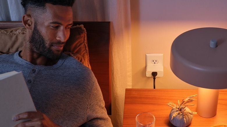 A person looking at a light with the Amazon Smart Plug in the background