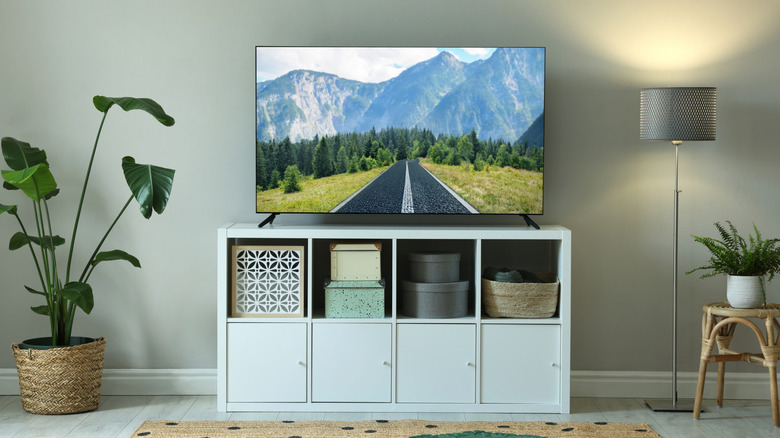 A TV on top of a white console TV stand in a living room