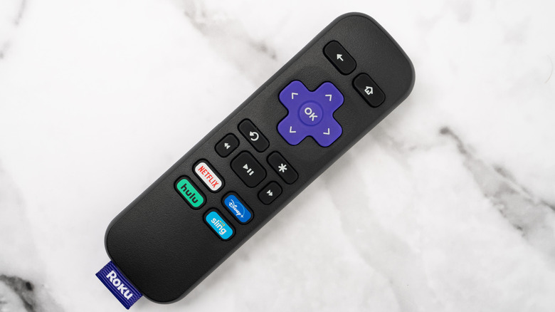 A roku remote centered on what looks like a grey marble tabletop