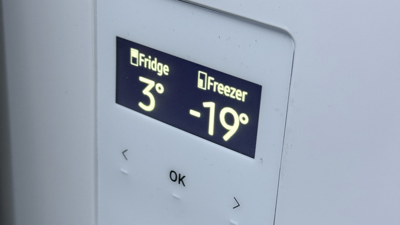 A digital thermometer showing temperatures in a fridge and freezer.