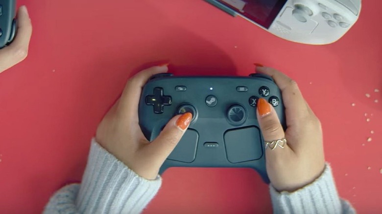 Steam Controller in a player's hands with red background and snacks.