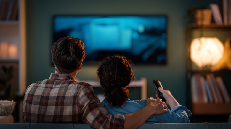 couple watching TV in a living room