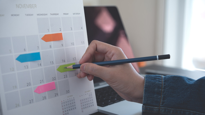 person using a planner to map out the next month